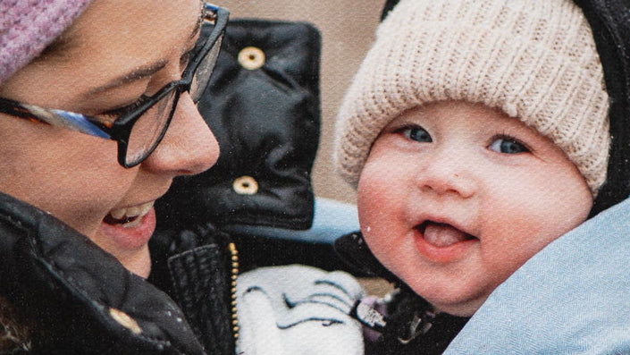 Happy mother and baby wearing winter attire, captured on a custom 8x8 Pure Modern Mini Canvas from Modern Canvas Company.